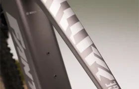 Primer plano de un cuadro de MTB eléctrica gris metalizado con la marca "Santic" y el modelo "Ridge 1.1" en letras blancas.