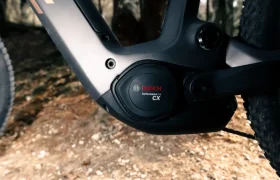Primer plano del sistema de motor Bosch CX Gen5 de una Fantic Sierra e-MTB, mostrando parcialmente el cuadro y el neumático delantero en un sendero de tierra.