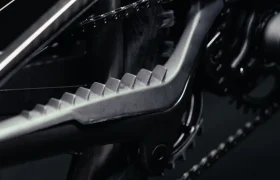 Primer plano de la vaina de una bicicleta UNNO MITH, que muestra un protector grande y en ángulo con parte de la cadena y los engranajes sutilmente visibles en el fondo.