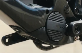 Primer plano de la carcasa del motor eléctrico de una bicicleta marcada con el logotipo de Avionic, unida a un elegante marco negro que recuerda al diseño de UNNO MITH.