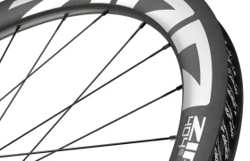 Primer plano de dos ruedas de bicicleta Zipp 404 S apiladas, con radios negros y el logotipo blanco en las llantas, perfectas para los ciclistas que buscan velocidad y calidad a un precio excelente.