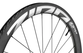 Primer plano de una rueda de bicicleta de carbono Zipp 404 S en el que se aprecian los radios y el llamativo logotipo «ZIPP» en blanco en la llanta, lo que destaca su velocidad y su diseño de alta gama. Ideal para quienes buscan rendimiento a un precio competitivo.