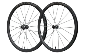 Dos ruedas de carbono negras Shimano Dura-Ace WH-R9370 con radios, colocadas en posición vertical y una al lado de la otra sobre un fondo blanco liso.