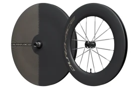Dos ruedas de bicicleta de alto rendimiento: una rueda trasera de disco y una rueda delantera de perfil alto, ambas con la marca Shimano Dura-Ace y fabricadas con ruedas de carbono de primera calidad. El modelo WH-R9370 está diseñado por expertos para su uso en carreras o contrarreloj.
