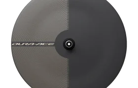 Una rueda trasera de disco para bicicleta Shimano Dura-Ace WH-R9370, fabricada con ruedas de carbono de primera calidad, que presenta un llamativo diseño bicolor dividido equitativamente por la mitad y un buje central para la fijación del eje.