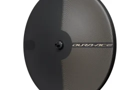 Una rueda trasera de bicicleta de carbono con disco de la marca Shimano Dura-Ace, con un patrón texturizado y radios de carbono, vista de perfil sobre un fondo blanco. Perfecta para ciclistas que buscan ruedas ligeras y componentes de alto rendimiento.