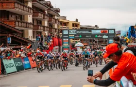 Ciclistas compiten en los Campeonatos del Mundo de Bicicleta de Montaña de la UCI de 2025 en Valais, Suiza, mientras el público observa cerca de la línea de salida, aclamando a estrellas como Jenny Rissveds.