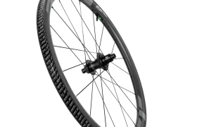 Una sola rueda de bicicleta negra con llanta de fibra de carbono, radios y un buje central, diseñada para ayudarte a rodar más rápido, mostrada sobre un fondo blanco.