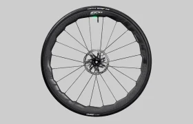 Una rueda de bicicleta Zipp 2026 de carbono negro con rotor de freno de disco y etiquetada "Zipp", diseñada para ayudarte a rodar más rápido, que se muestra sobre un fondo gris simple.
