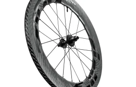 Una rueda de bicicleta Zipp 2026 de fibra de carbono con llanta aerodinámica de sección profunda y radios negros, diseñada para rodar más rápido, fotografiada sobre un fondo blanco.