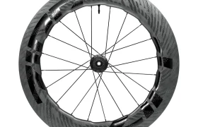 Una rueda de bicicleta de fibra de carbono con llanta aerodinámica de sección profunda, radios negros y la marca Zipp 858 NSW en la parte superior, diseñada para rodar más rápido. Descubre la innovación que anticipa la próxima evolución de Zipp 2026.