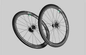 Un par de ruedas de bicicleta Zipp 2026 de fibra de carbono negra con frenos de disco, diseñadas para rodar más rápido, mostradas sobre un fondo gris liso.