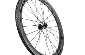 Una rueda de bicicleta de fibra de carbono Zipp 2026 con una llanta aerodinámica de sección profunda y radios negros, diseñada para ayudarte a rodar más rápido, que se muestra aislada sobre un fondo blanco.