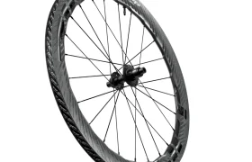 Se muestra una sola rueda de bicicleta de fibra de carbono Zipp 2026 con un borde aerodinámico profundo y radios negros sobre un fondo blanco, diseñada para ayudarte a rodar más rápido.