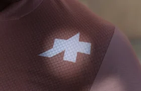 Primer plano de una persona que lleva un maillot de ciclismo ASSOS MILLE GT S11 de color malva con un logotipo geométrico blanco en el hombro, que muestra la evolución real y el confort inteligente; sólo se ven parte de la cara y la parte superior del torso.