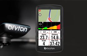 Una computadora para bicicleta Bryton que muestra la velocidad, la pendiente, el tiempo de recorrido y la distancia con un perfil de elevación de color en la pantalla, montada en un manillar.