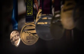 Primer plano de varias medallas colgadas de cintas, con la medalla de oro central rotulada "ENDURO 2023" y un gráfico de montaña, como se ve en la entrevista a Jordi Bagó sobre sus logros.
