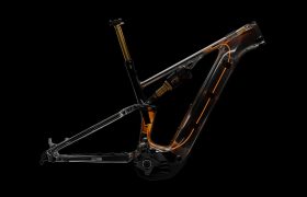 Se muestra, sobre un fondo negro, un cuadro de bicicleta de montaña transparente con los componentes internos y el cableado a la vista, incluida la avanzada tija electrónica FOX Transfer Neo.