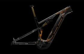 Un cuadro de bicicleta de montaña con suspensión total y optimizado para e-bike, con el paso de cables interno a la vista y líneas estructurales resaltadas, representado sobre un fondo negro.