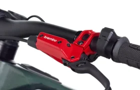 Primer plano de un manillar de bicicleta con una maneta de freno Brembo GR-PRO roja acoplada, que muestra el agarre y parte del cuadro e-MTB, perfecto para los ciclistas que buscan prestaciones frenos para gravedad.