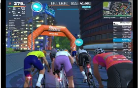 Una vista en primera persona de una carrera ciclista virtual con indicadores de rendimiento en pantalla y un panel con la clasificación a la derecha.