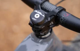 Primer plano del manillar y la potencia de una bicicleta, equipados con puños ReaFlex 6.0 que ofrecen un agarre y un control superiores. La marca «SENSOR» es visible en el cuadro de la bicicleta, mientras que el manillar Leatt Launch Control 6.0 combina a la perfección con una tapa superior «NSB» en la potencia Gravity 6.0, lo que le confiere un aspecto elegante y de alto rendimiento.
