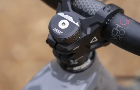 Primer plano del manillar y la potencia de una bicicleta, en el que se aprecia la marca «SENSOR» en el cuadro; se muestra el manillar Leatt Launch Control 6.0, así como la tapa superior y parte del cable de freno.