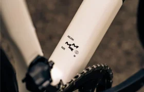 Primer plano de un cuadro de bicicleta en el que aparece la etiqueta "AELION SIZE M" junto a una cadena y un pedal, lo que pone de relieve el tamaño mediano de esta bici total MMR Aelion.