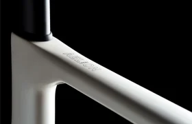 Primer plano de un cuadro de bicicleta Aelion SL blanco mate con la inscripción "AELION" sobre fondo negro, una auténtica bici total de la gama MMR Aelion.