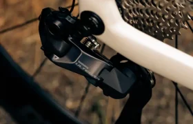 Primer plano del cambio trasero, el casete y la rueda de una MMR Aelion, en el que se muestran en detalle los componentes del engranaje total de la bicicleta con un toque de acento asturiano.