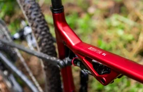 Primer plano de un cuadro de bicicleta de montaña MMR Kenta rojo con la etiqueta "KENJA S4" y suspensión trasera visible, mostrando la evolución total con parte del neumático trasero y la tija del sillín a la vista.