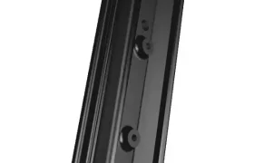 Soporte de montaje en pared de plástico negro con tres orificios para tornillos, visto en ángulo sobre un fondo blanco, perfecto para la configuración de MMR Kenta y la evolución total en organización.