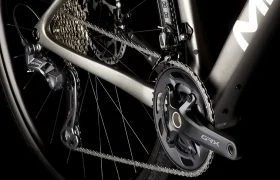 Primer plano de la transmisión de una bicicleta MMR Simun que muestra la cadena, el desviador trasero, el cassette y el juego de bielas delantero etiquetados "GRX" sobre un fondo oscuro.