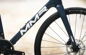 Primer plano del cuadro delantero y la rueda de una bicicleta, con el logotipo "MMR Simun" en el cuadro y un neumático Hutchinson.