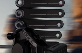 Primer plano de un componente electrónico SRAM negro con varias bielas negras a juego en vertical en el fondo.