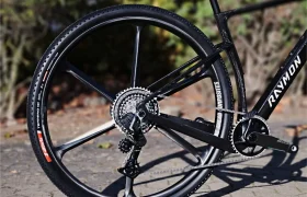 Vista trasera de una bicicleta de gravel RAYMON equipada con una rueda de carbono con radios, un desviador y una transmisión.