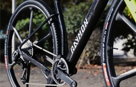 Primer plano de un prototipo de cuadro negro de bicicleta de grava RAYMON con un juego de bielas SRAM Force y neumáticos Vittoria Terreno.