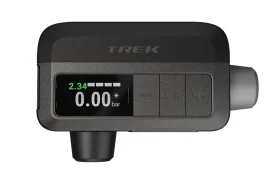 Un manómetro digital para neumáticos que muestra 2,34 con botones de control y un accesorio de boquilla, ideal para el inflado de ruedas, sobre fondo blanco.