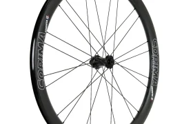 Una rueda de bicicleta negra Corima Essentia 42 de fibra de carbono con radios y llanta de sección profunda, ideal para la conducción de resistencia en grava y ruedas, vista de perfil sobre un fondo blanco.