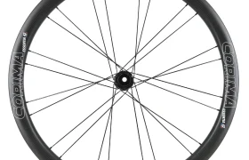 Una rueda de bicicleta de carbono Corima Essentia 42 negra con radios negros y marca blanca, ideal para carreras de resistencia sobre gravilla o ruedas, vista de perfil sobre un fondo blanco.
