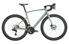Una moderna bicicleta de carretera SCOTT Addict con manillar rebajado, frenos de disco y neumáticos anchos, mostrada en color verde claro sobre fondo blanco.
