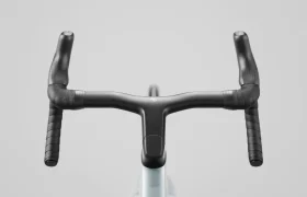 Primer plano del manillar negro de una bicicleta de carretera SCOTT Addict, fotografiado desde arriba sobre un fondo liso gris claro.