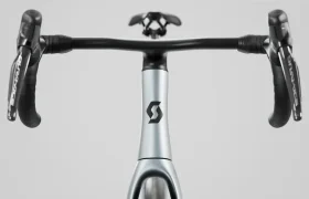 Primer plano del manillar, la potencia y el cuadro delantero de una bicicleta SCOTT Addict con el logotipo de Scott, fotografiados desde la perspectiva del ciclista sobre un fondo liso.