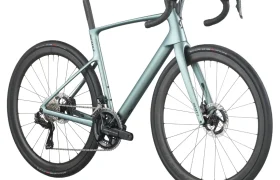 Una bicicleta de carretera SCOTT Addict de color azul claro con manillar rebajado, frenos de disco y neumáticos finos se muestra desde un ángulo trasero sobre un fondo blanco.