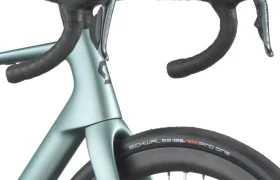 Primer plano del manillar rebajado, la horquilla delantera y la rueda con cubierta Schwalbe Pro One de una bicicleta de carretera SCOTT Addict, que muestra un diseño moderno y componentes de primera calidad.
