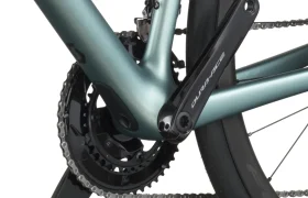 Primer plano de una transmisión de bicicleta SCOTT Addict que muestra los platos, el plato, la cadena y el neumático trasero en un cuadro de bicicleta verde azulado mate.