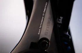 Primer plano del cuadro negro de la bicicleta SCOTT Strike 2027, con la inscripción «Strike», que cuenta con un potente motor Bosch CX Performance Powertube y una horquilla de suspensión visible de 150 mm.