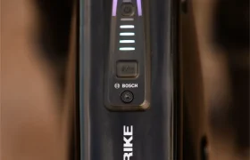 Primer plano del cuadro negro de la bicicleta SCOTT Strike 2027, con la inscripción «STRIKE», que incorpora un panel de control Bosch con cuatro barras luminosas y un botón de encendido, lo que pone de relieve la comodidad y el rendimiento avanzado del motor Bosch CX.