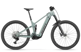 Se muestra, de perfil y sobre un fondo blanco, una bicicleta de montaña eléctrica SCOTT Strike 2027 de color gris claro, con suspensión delantera, neumáticos anchos y un tubo superior inclinado. Equipada con un motor Bosch CX para mayor comodidad, esta versátil bicicleta eléctrica está diseñada tanto para recorridos suaves como para terrenos accidentados.