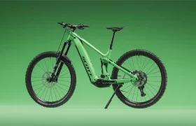 Bicicleta de montaña eléctrica Green SCOTT Strike 2027 con neumáticos negros y un pie de apoyo, equipada con un potente motor Bosch CX para mayor comodidad, expuesta sobre un fondo verde a juego.